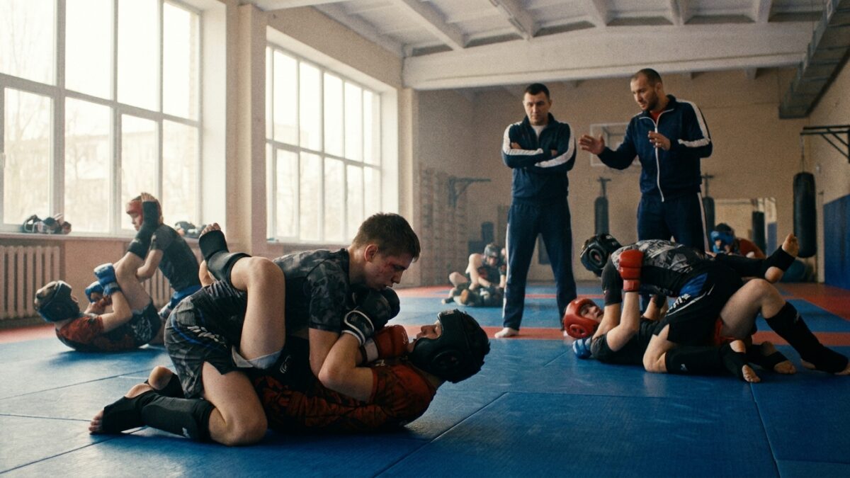 Jovens atletas em treino de Artes Marciais Mistas num ginásio especializado