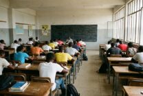 Sala de aulas universitária com estudantes em ambiente académico angolano