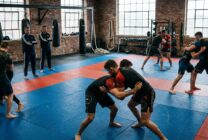 Atletas de artes marciais mistas em sessão de treino intensivo em ginásio desportivo
